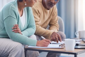 Senior couple, documents and sign contract for life insurance or home mortgage. Discussion, signature and retired elderly man and woman signing legal paperwork for will or loan application together.