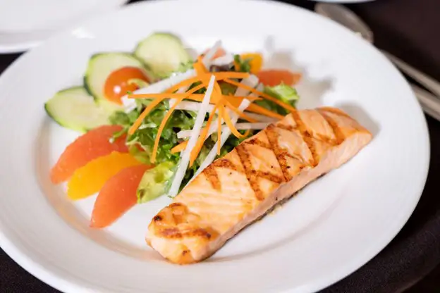 grilled salmon and a fresh salad on a white plate