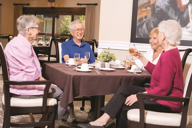 a group of seniors sitting at a table in Freedom Village's dining room