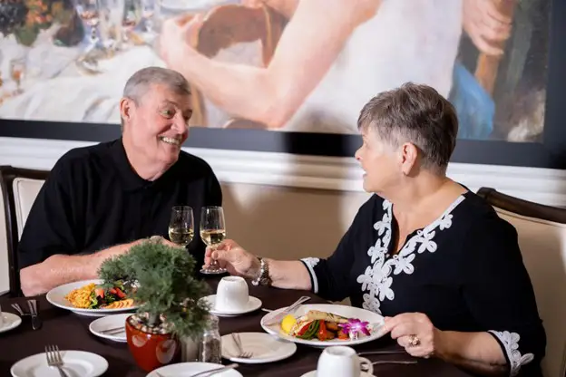 a senior couple sitting at a table in Freedom Village's dining room