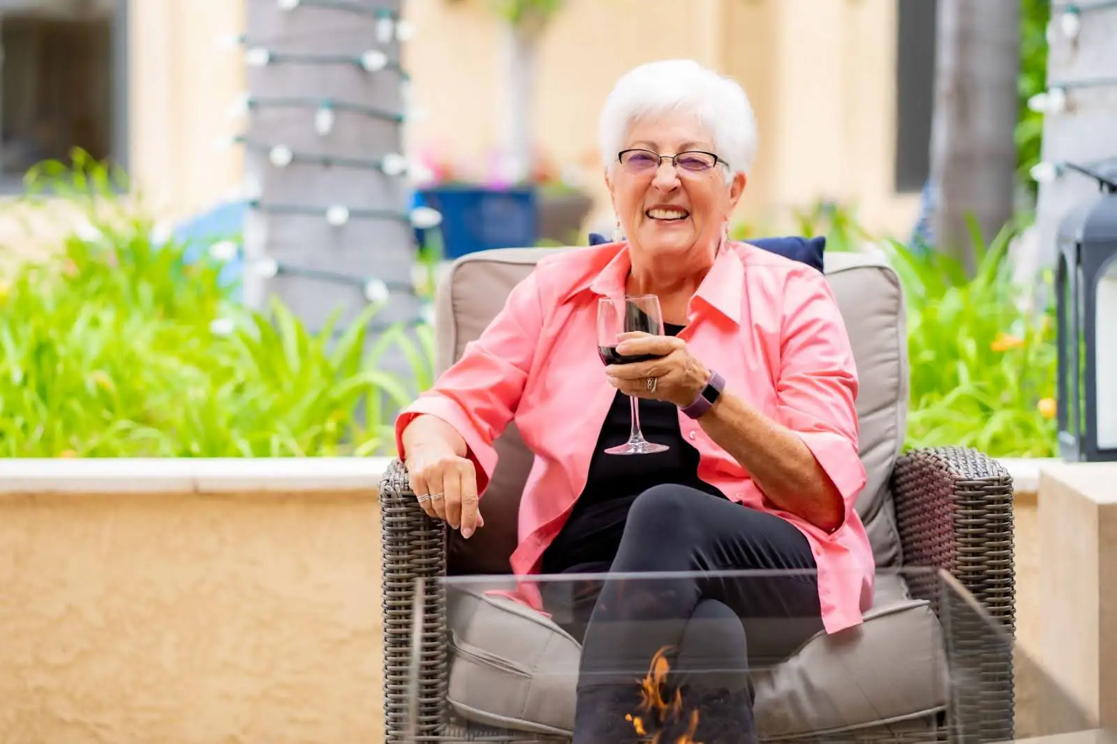 Senior woman sipping a glass of red wine in an outdoor dining area