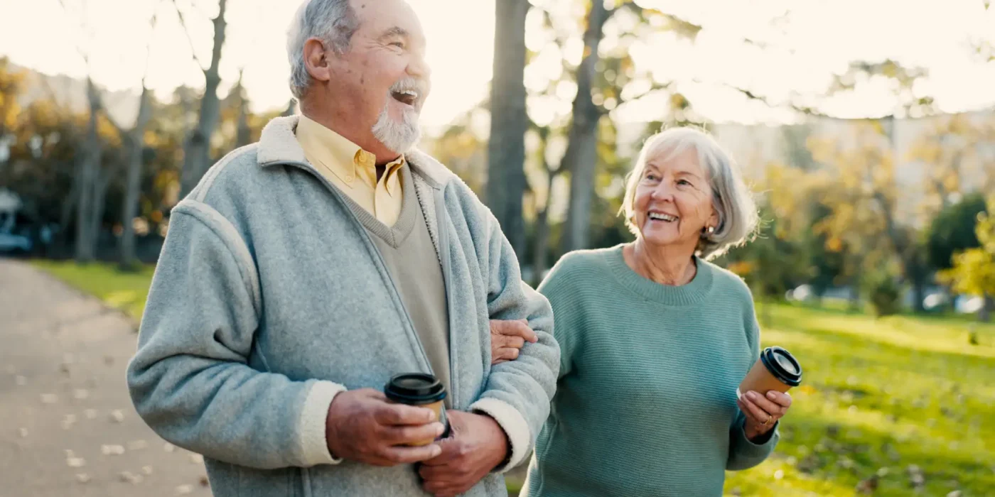 a senior couple at a Life Plan Community taking a walk on a fall day