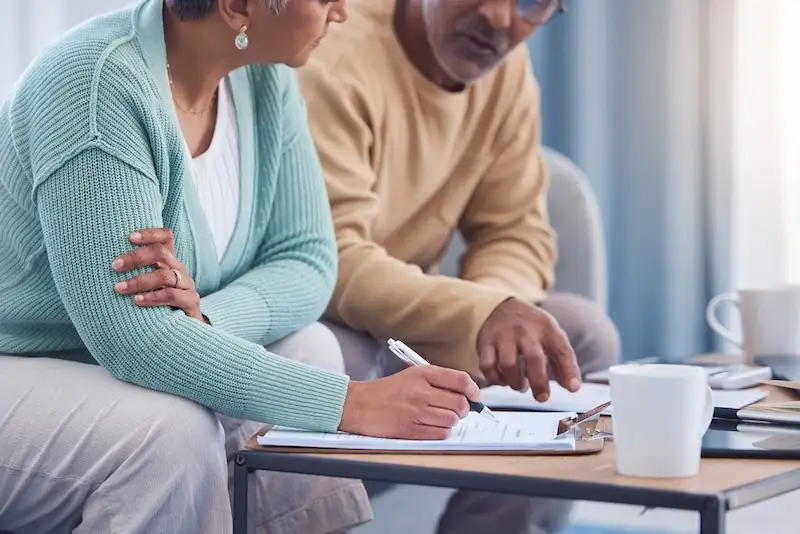 Senior couple, documents and sign contract for life insurance or home mortgage. Discussion, signature and retired elderly man and woman signing legal paperwork for will or loan application together. senior estate planning